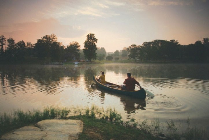 Father and son canoeing on lake.