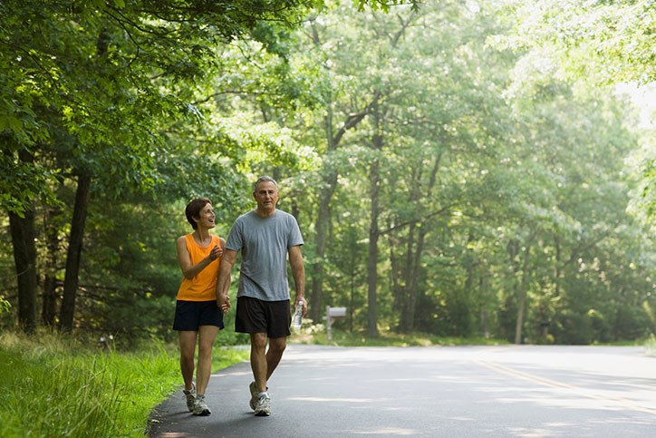 Couple walking along wooded trail in Sterling on the Lake.